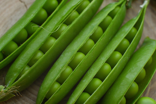 New harvest of fresh ripe green peas. legumes.Green peas and pea pods on wooden background.Close-up