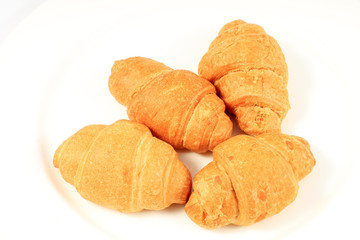 close up of croissants on plate on white background