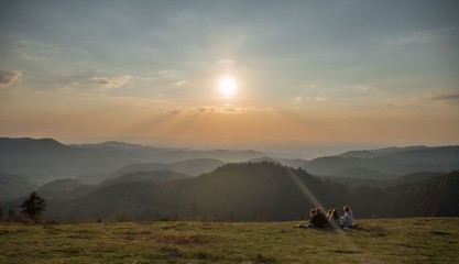 Family having a picnic atop a hill during sunset in Black forest, Germany