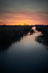 Breathtaking shot of a spanish polder in a field and the rising sun in the background