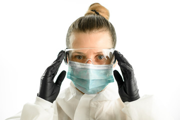portrait of young woman in surgical mask and protective glasses on grey background