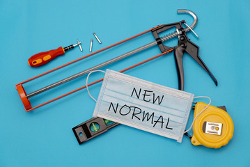 "New Normal" on masks and tools with blue background, New Normal concept.