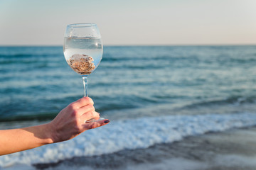 Glass with shells on a background of the sea