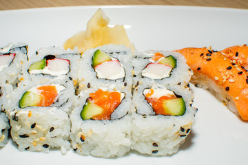 A selection of sushi rolls with salmon, tuna, cucumber and soy sauce dip.