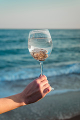 Glass with shells on a background of the sea