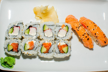 A selection of sushi rolls with salmon, tuna, cucumber and soy sauce dip.