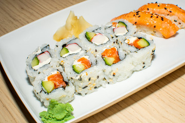 A selection of sushi rolls with salmon, tuna, cucumber and soy sauce dip.