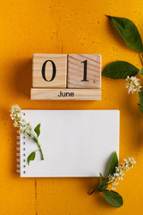 calendar June 1, blank notebook for your text on a yellow background with flowers. The concept of the beginning of summer, Children's Day. Copy space
