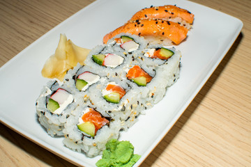 A selection of sushi rolls with salmon, tuna, cucumber and soy sauce dip.