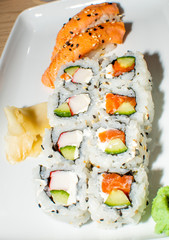 A selection of sushi rolls with salmon, tuna, cucumber and soy sauce dip.