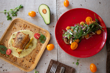Healthy salad on red plate and fish