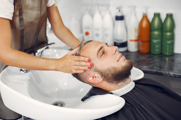 Obraz na płótnie Canvas Man with a beard. Hairdresser with a client. Woman washing man's head