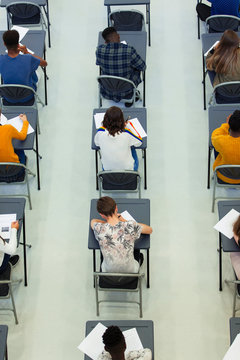 View From Above High School Students Taking Exam At Desks In Classroom