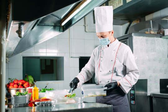Food delivery in the restaurant. The chef prepares food in the restaurant and packs it in disposable dishes.
