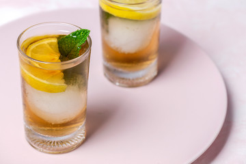 tea with ice, mint and lemon wedges on white table