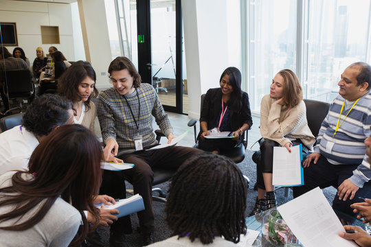 Business people talking in circle in conference room meeting