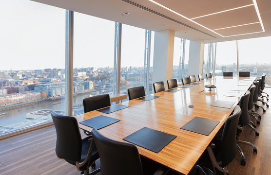 Long conference table in modern highrise office overlooking city