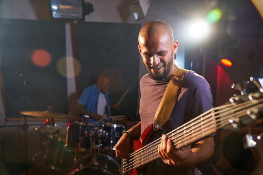 Male guitarist and drummer performing on stage