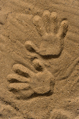 Many Footprints on the sand beach. Big and small footprints.