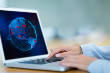 Female scientist looking at global pandemic outbreaks on laptop