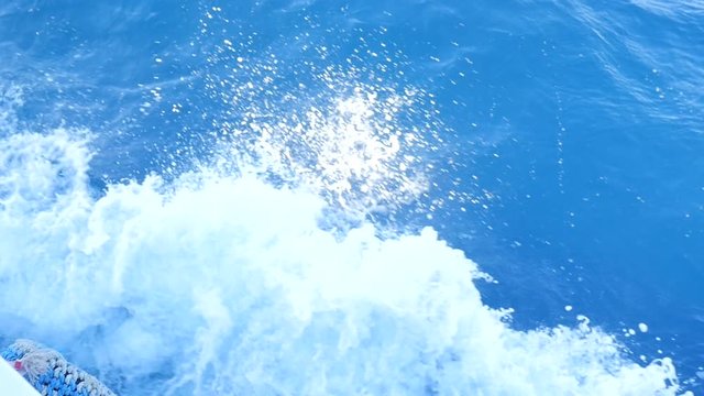 White Foam Splashes Fly From the Ship's Side. Blue Waves are Swaying the Pleasure Yacht. The Boat Quickly Moves Along the Water to the Coast.