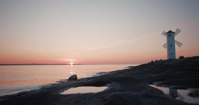 Zach&oacute;d słońca nad morzem - wiatrak.