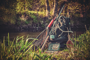 Fishing rod, backpack and fishing gear on the river bank. Tenkara.