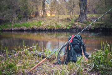 Obraz na płótnie Canvas Fishing rod, backpack and fishing gear on the river bank. Tenkara.
