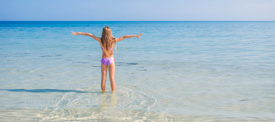 Adorable little girl have fun at tropical beach during vacation