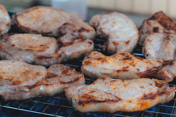 to cook meat on the coals on the grate of the grill