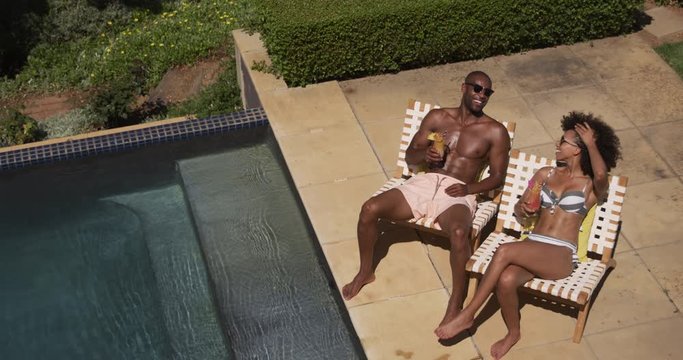 Happy mixed race couple enjoying the pool during a sunny day