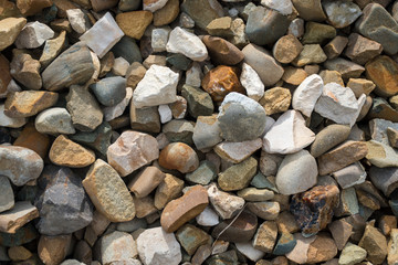 Background with stones of different colors. Stone for construction. Building stones. Building material. Various pebble stones texture. Rock texture background. 