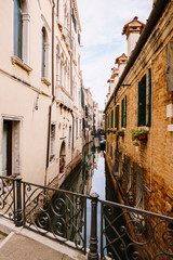 A narrow canal in Venice. Small canals between houses, a few meters. Beautiful little bridges between the streets.