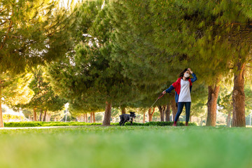 woman wearing a protective mask is walking alone with a dog outdoors because of the corona virus pandemic covid-19