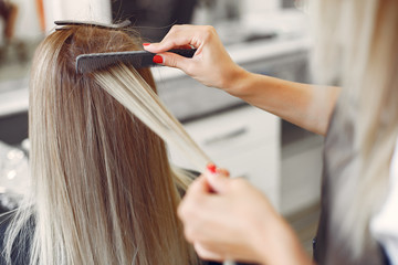 Naklejka premium Hairdresser working with hear her client. Woman in a hair salon