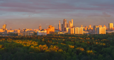 Fototapeta premium Moscow city skyline at sunset , panoramic view. Amazing colourful scenery of the park and sunlit buildings. 