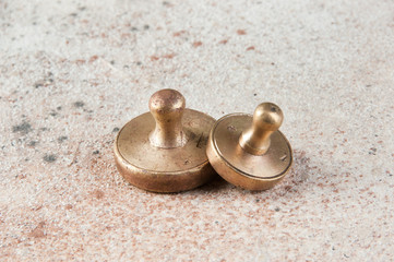 Fototapeta na wymiar Two antique bronze weights for scales on concrete background.