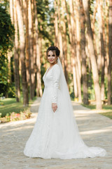 cute bride holds a bouquet in a beautiful wedding dress,beautiful bride stands with her back