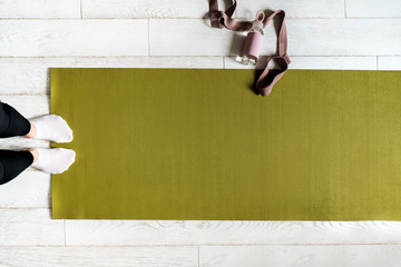 Woman legs on an exercise mat. Female preparing practicing yoga at home. National yoga day...
