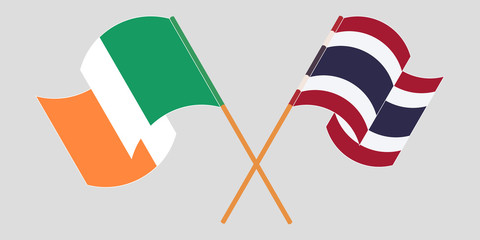 Crossed and waving flags of Ireland and Thailand