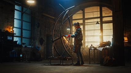 Obraz na płótnie Canvas Beautiful Female Artist Uses an Angle Grinder to Make Brutal Metal Sculpture in Studio. Tomboy Girl Polishes Metal Tube with Sparks Flying Off It. Contemporary Fabricator Creating Abstract Steel Art.