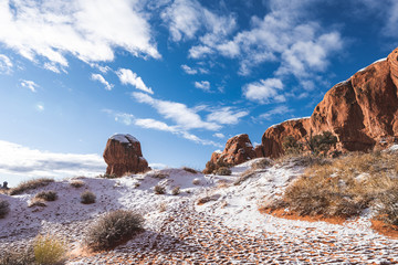 Double Arch at Arches National Park in snow when sun is rising.