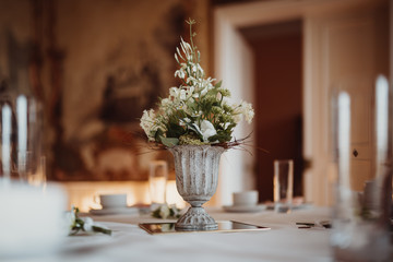 photo of a flower vase on a table with candles