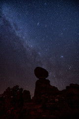 Night sky and Milky Way behind Balanced Rock at Arches National Park after sunset.