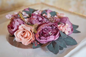 Basket with sweets stands on the table . Artificial pink rose . Engagement flower.
