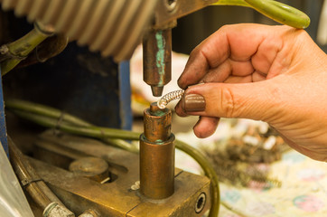 Close-up photo of woman's hand electronically welding a part.