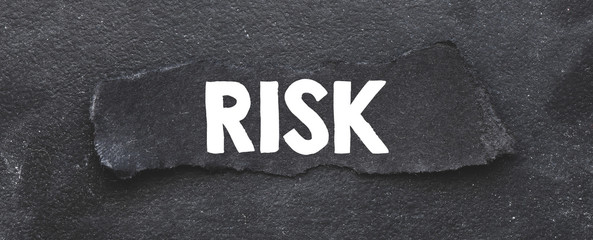 RISK word on black card and black background.