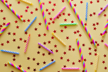 festive birthday background with colored candles for cake, straws and stars