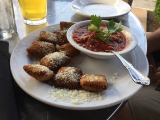 Toasted Ravioli, The Hill, St. Louis, Missouri, USA - Toasted ravioli sprinkled with parmesan cheese with marinara sauce garnished with parsley on a white plate at an Italian restaurant on The Hill