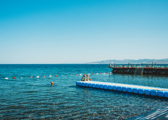 Obraz premium Sea pier without people and ships. Blue sky